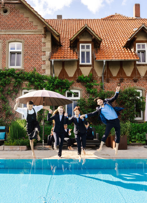 Auszubildende springen in einen Pool im Familienhotel