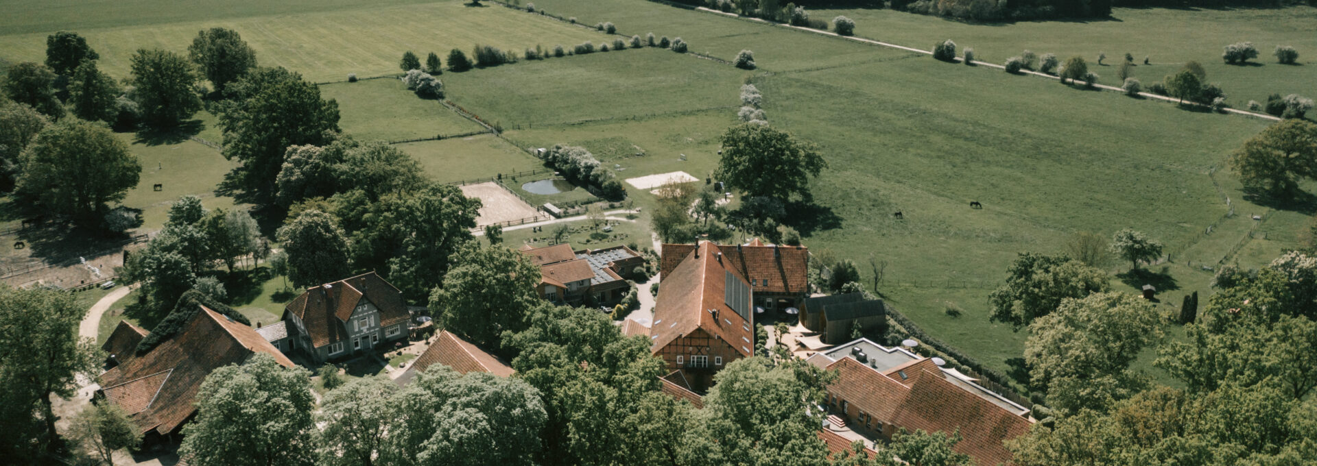 Eine Luftaufnahme vom Landhaus Averbeck mit vielen grünen Feldern.
