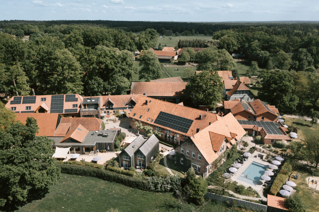 Luftaufnahme vom Landhaus Averbeck mit Bauernhof, Pool und grüner Natur