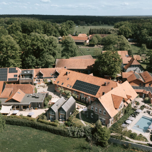 Luftaufnahme vom Landhaus Averbeck mit Bauernhof, Pool und grüner Natur