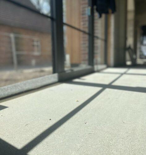 Die Schatten eines Fensterbogens auf dem Boden