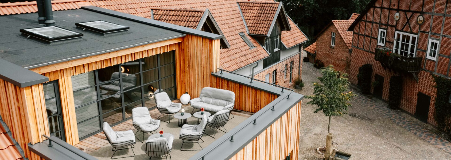 Eine gemütliche Lounge auf der Dachterrasse des Averbeck Hotels mit schöner hölzerner Fassade.