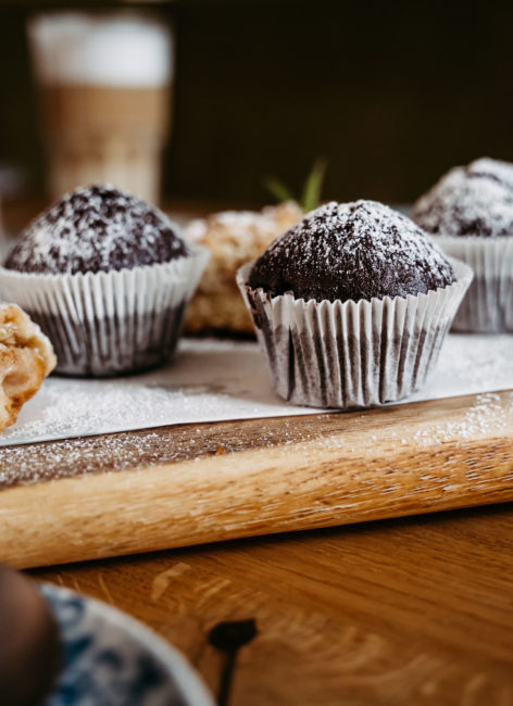 Detailaufnahme eines Schokoladen Muffins mit Puderzucker bestreut.