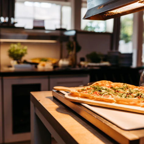 Detailaufnahme Flammkuchen mit Tomate und Rucola am Abendbuffet.