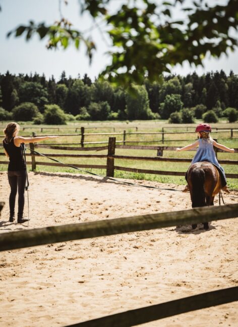 Kleines Mädchen reitet freihändig auf einem Pony beim all inclusive Familienurlaub