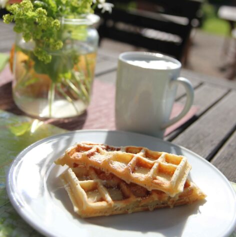 Frühstückstisch mit belgischen Waffeln und einer Tasse Kaffee