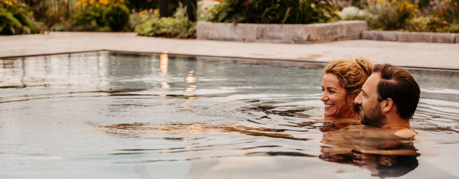 Ein Paar schwimmt zusammen im Außenpool des Kinderhotels mit Schwimmbad