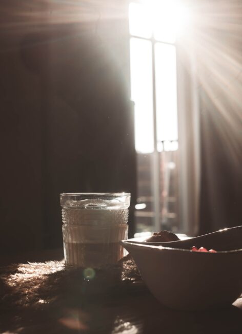 Sonnenstrahlen fallen auf einen Frühstückstisch mit Kaffee und einer Schüssel im Familienhotel in Niedersachsen