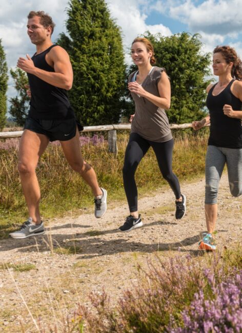Drei Personen joggen über den Feldweg beim all inclusive Familienurlaub
