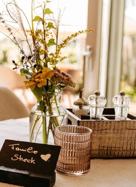 Blumenstrauß und Platzkarte auf dem Tisch im Restaurant Kleine Möhre