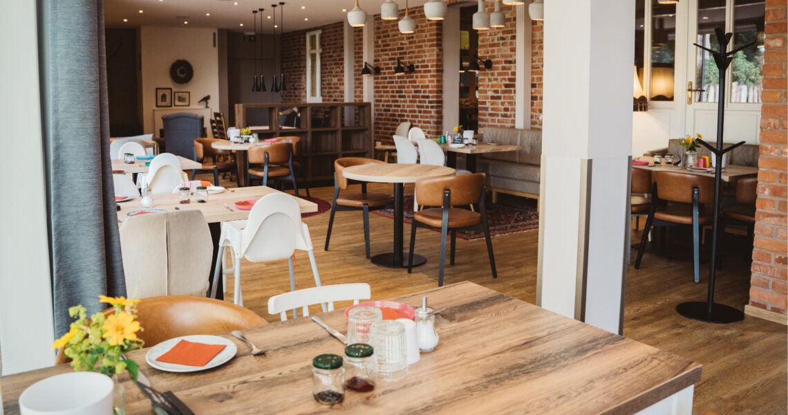 Ein Blick in das Restaurant Kleine Möhre mit gedackten Tischen und Backsteinwänden