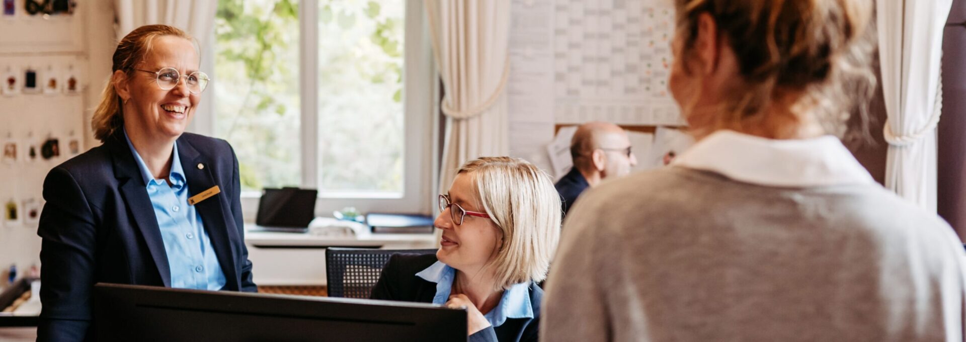 Das fröhliche Rezeptionsteam beim Check-in eines Gastes