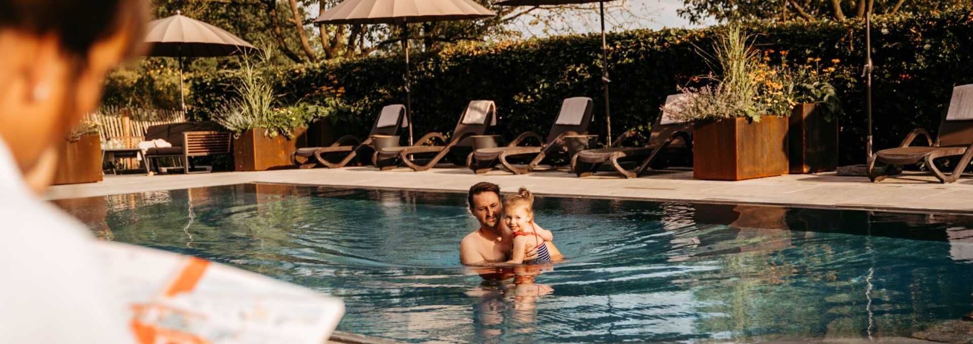 Detailaufnahme im Pool des Familienhotel und Bauernhof Averbeck wo ein Vater mit seiner Tochter badet.