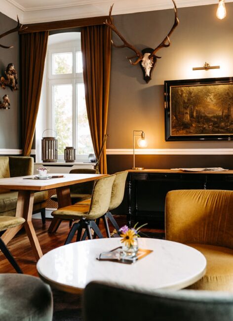 Einblick in die Jagdstube mit grünen Sesseln und Jagdtrophäen