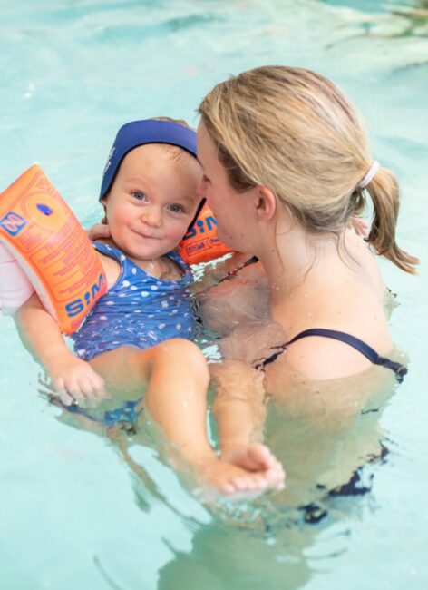 Mutter mit ihrer jungen Tochter im Pool beim all inclusive Familienurlaub