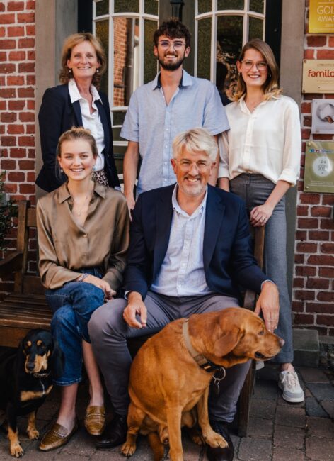 Die Familie Averbeck-Pennington sitz mit ihren beiden Hunden vor dem Landhaus Averbeck