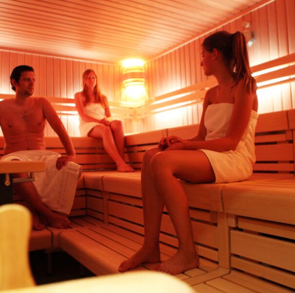 Drei Personen sitzen in der Sauna im Kinderhotel mit Schwimmbad