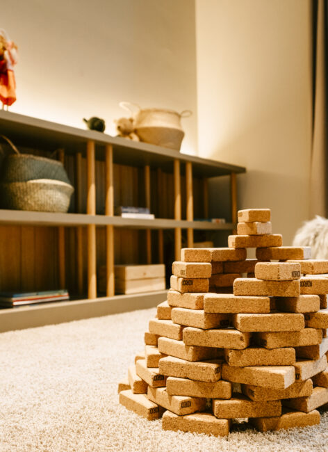 Nahaufnahme eines Turms aus Holzklötzen im Spielzimmer des Hotels mit Kinderbetreuung.