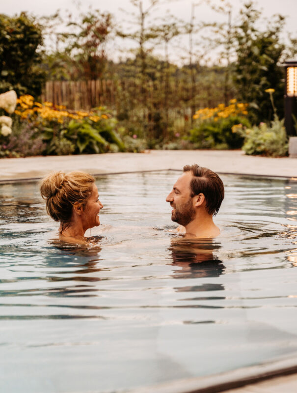 Paar schwimmt im Außenpool im Familienhotel mit Bauernhof