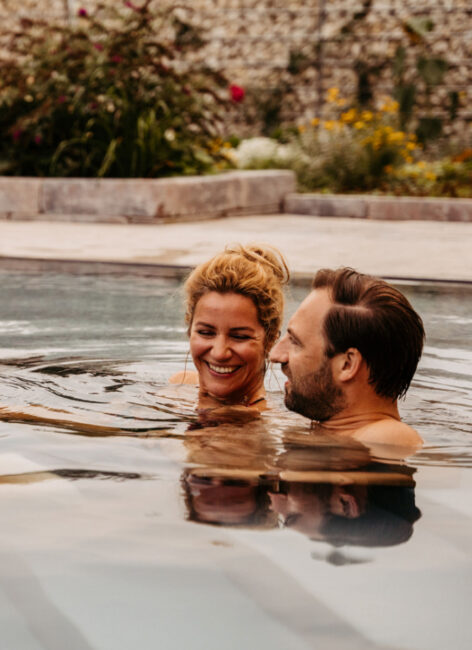 Ein Paar schwimmt im Außenpool im Familienhotel mit Bauernhof