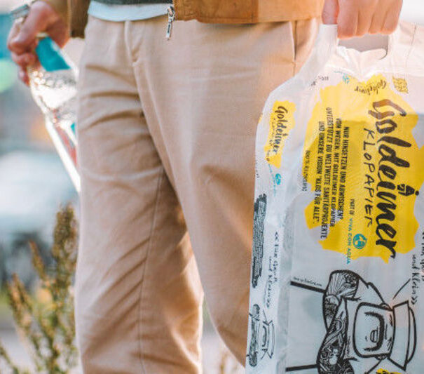 Person hält eine Packung Klopapier und eine Flasche Wasser in den Händen im Landhaus Averbeck