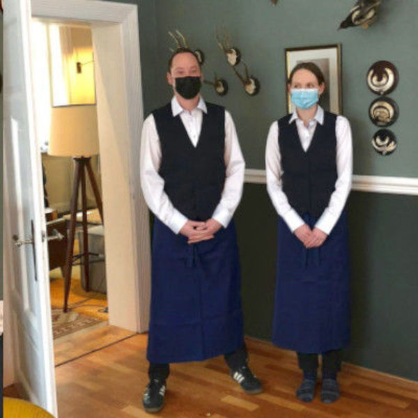 Zwei Mitarbeiter in Arbeitskleidung mit Masken