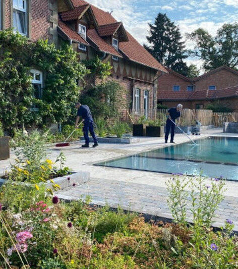 Zwei Personen bei der Poolreinigung des neuen Außenpools im Landhaus Averbeck